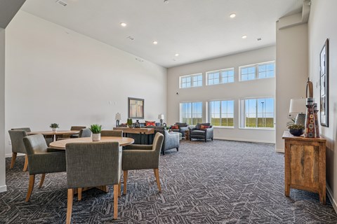 A spacious living room with grey chairs and a carpeted floor.