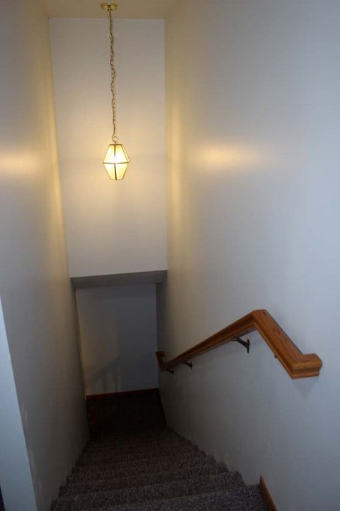 A staircase with a light hanging from the ceiling.