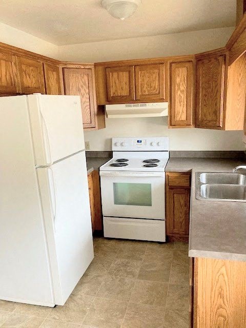 a kitchen with a white stove and a refrigerator