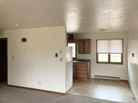 an empty house with a kitchen and a window