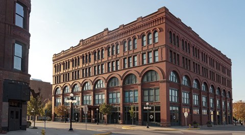 A large red brick building with many windows is in the foreground.