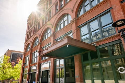 A building with a large window and a green awning.