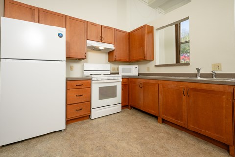 A kitchen with brown cabinets and white appliances.