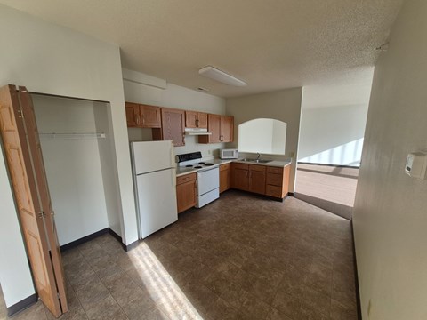 A kitchen with white appliances and brown cabinets.