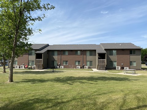 A large building with a green lawn in front.