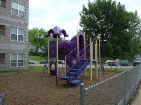 A purple playground slide with a blue staircase.