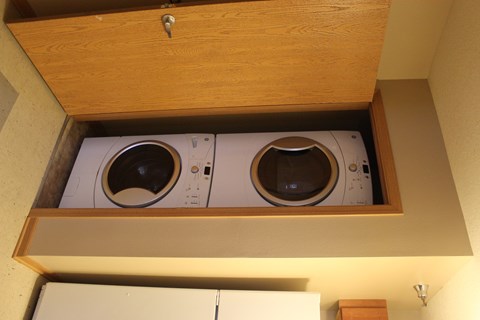 Two washing machines are installed in a cabinet.