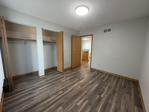 A room with wooden floors and a closet with a sliding door.