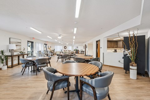 A conference room with a large table surrounded by grey chairs.