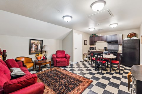 A living room with red chairs and a black and white checkered floor.