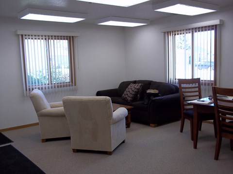 A living room with a couch, chairs, and a table.