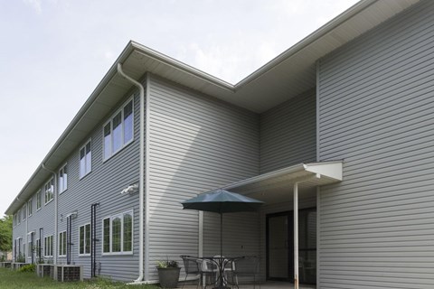 A house with a grey siding and a white roof.