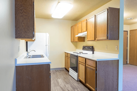 A kitchen with wooden cabinets and a white countertop.