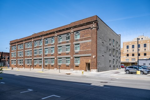 A large brick building with a parking lot in front.
