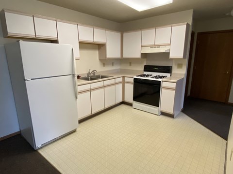 A kitchen with white appliances and white cabinets.