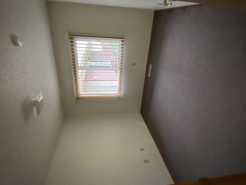 A room with a window and a wall on the right side.