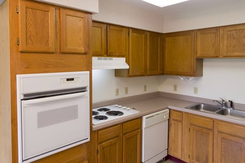 A kitchen with wooden cabinets and a white oven.