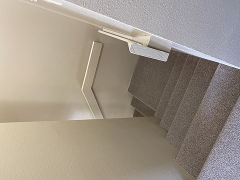 A close up of a white curtain rod.