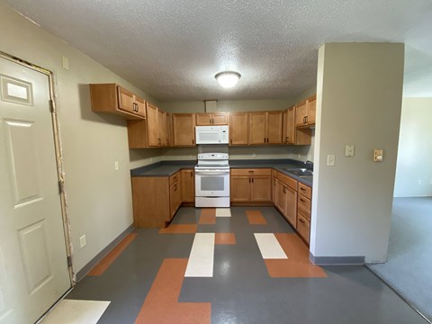 A kitchen with wooden cabinets and a black countertop.