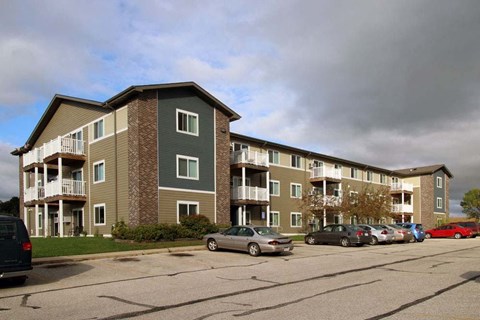 Apartment building with cars parked in front.