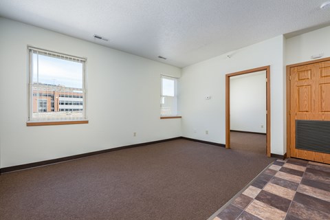 Empty room with brown carpet and white walls.