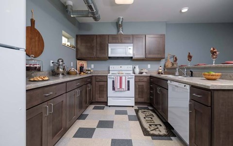 A kitchen with a white dishwasher and a black and white checkered floor.