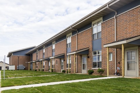A long brick building with a white trim around the windows and doors.