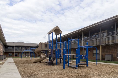 A playground with a blue structure and a slide.