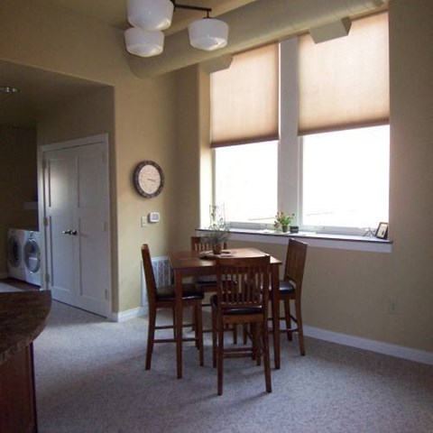 A dining room with a table and chairs.