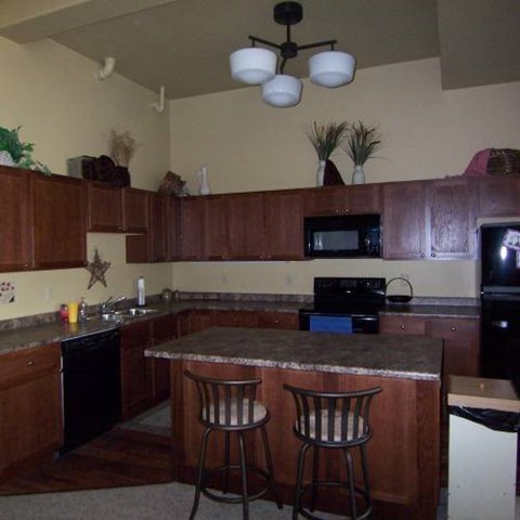 A kitchen with a bar stool in front of the counter.