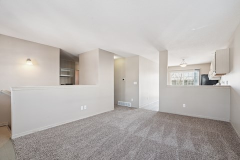A spacious living room with a carpeted floor and a window.