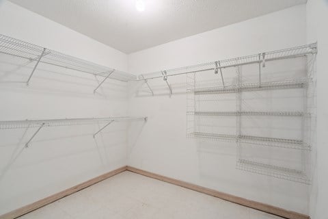 Empty room with wire shelving and white walls.