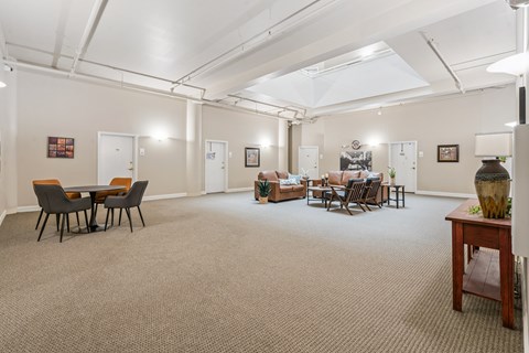 A spacious room with a carpeted floor and furniture.
