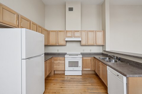 A kitchen with wooden cabinets and a white refrigerator.