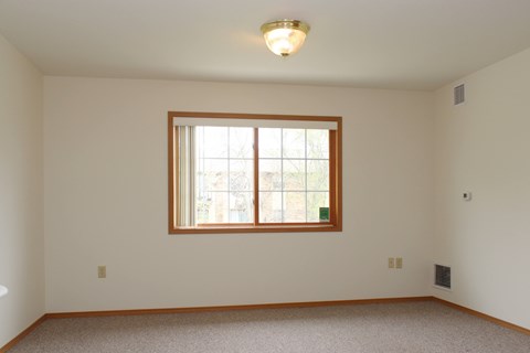 A room with a window and a ceiling light.