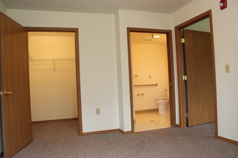 A bathroom with a toilet and sink is visible through an open door.