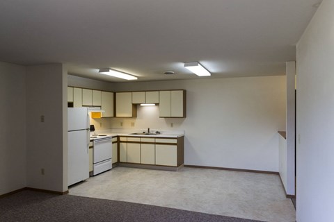 A kitchen with white cabinets and a white refrigerator.
