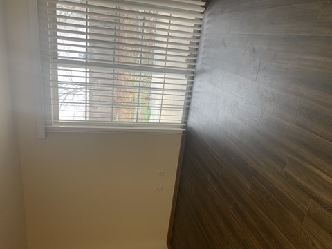 A window with blinds is open, letting in light.