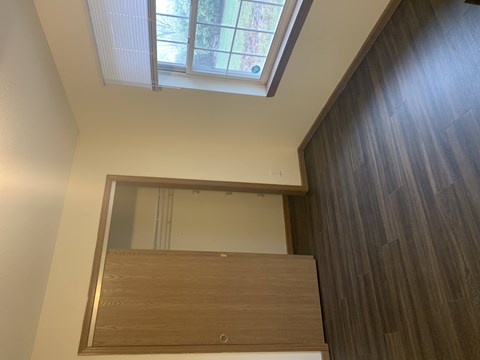 A mirror is mounted on a wall above a wooden door.