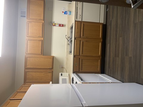 A white fridge in a kitchen with wooden cabinets.