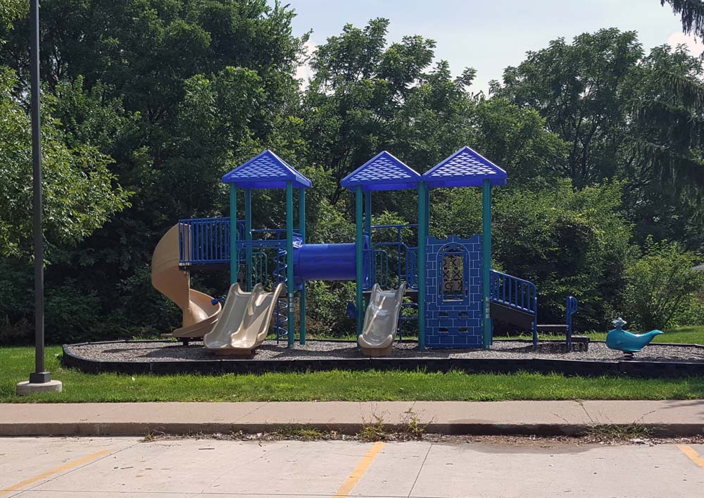 A playground with a blue slide and two blue towers.