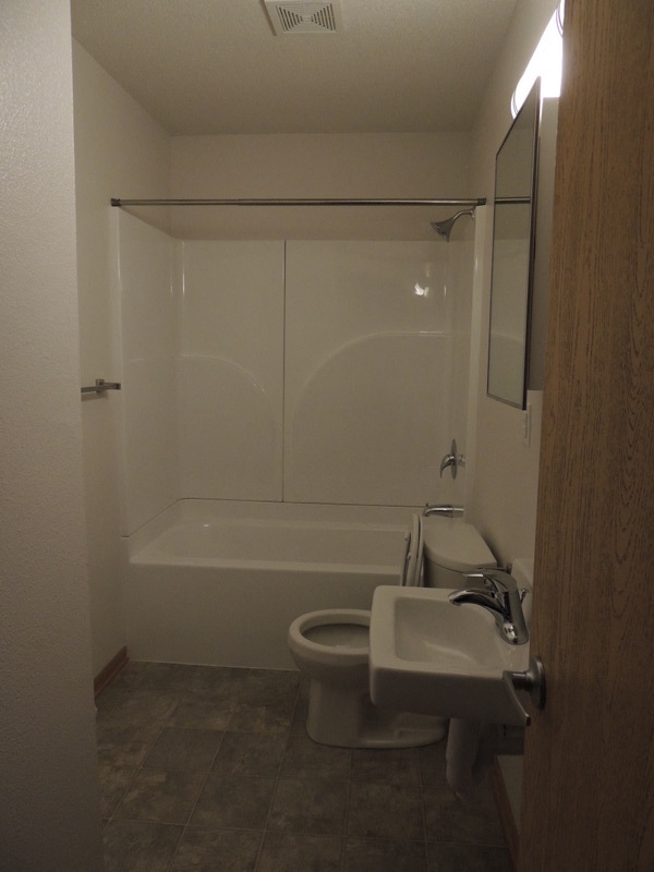 A white toilet and sink in a small bathroom.