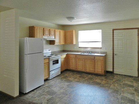 a kitchen with white appliances and wooden cabinets