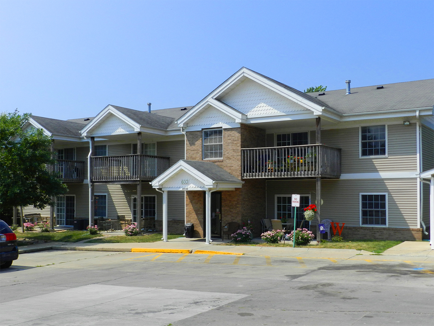 A large apartment complex with a parking lot in front.