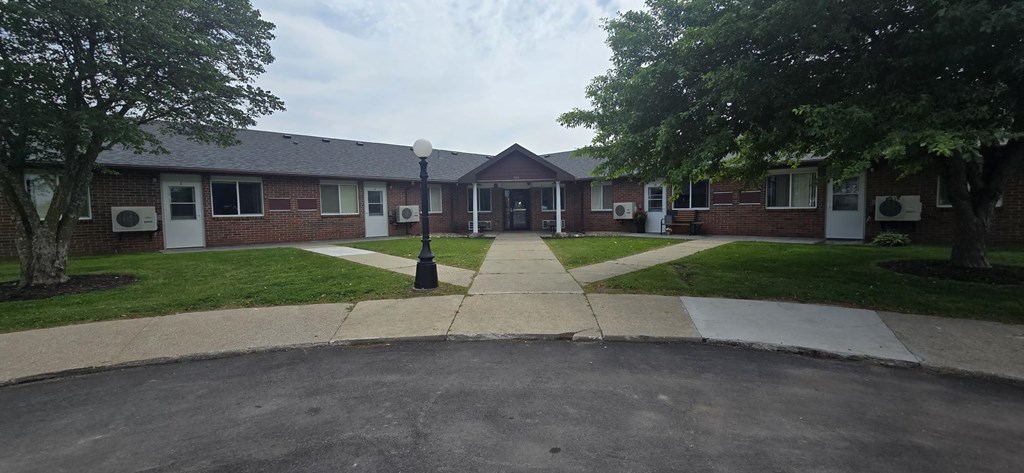 A small building with a white sign in front of it.