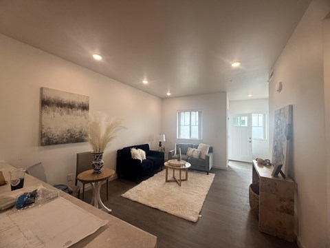 A living room with a couch, a coffee table, and a painting on the wall.