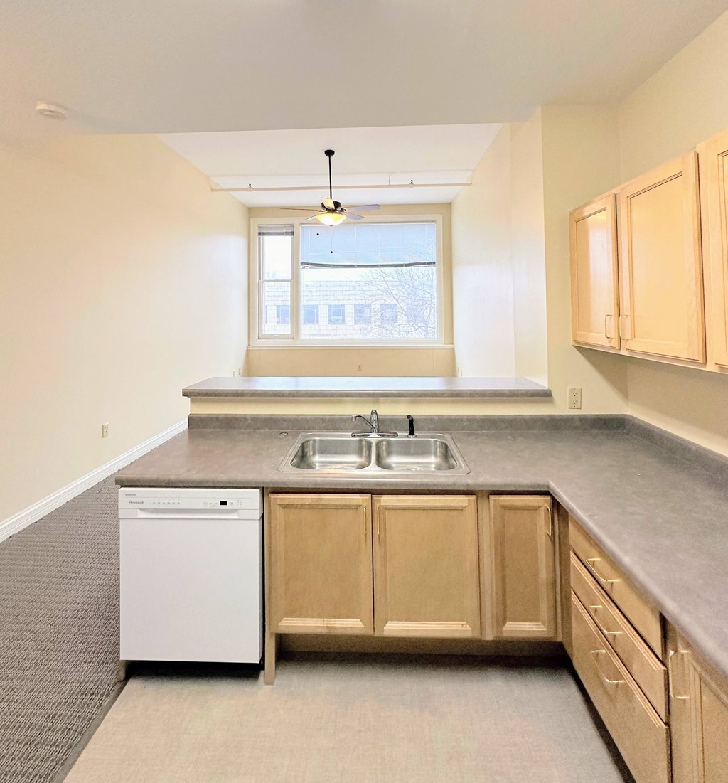 an empty kitchen with a sink and a window