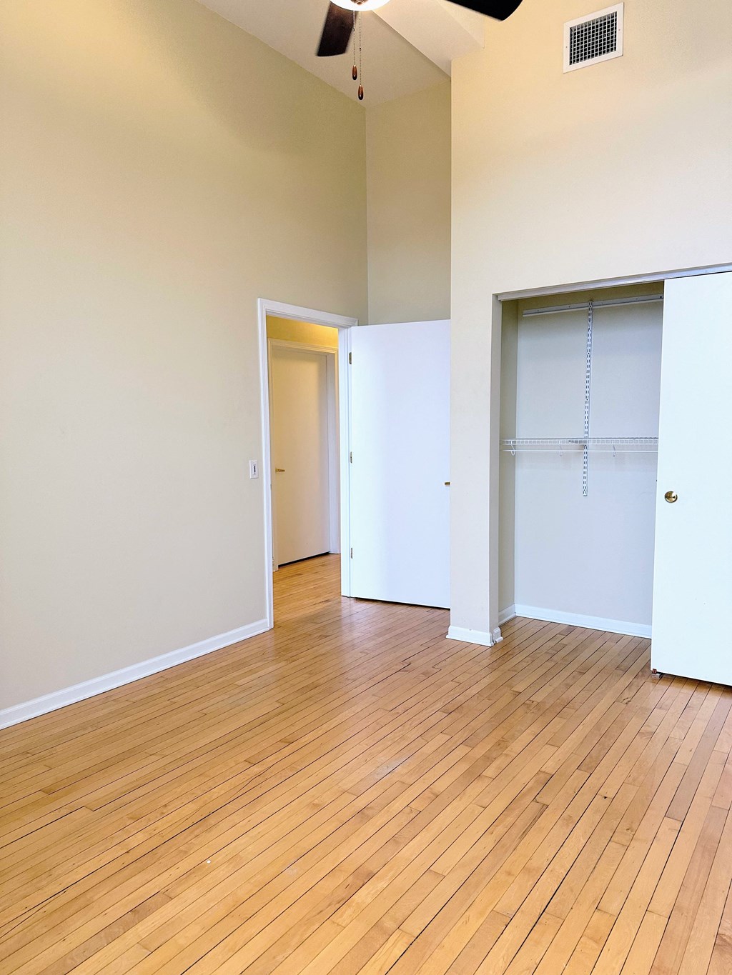an empty living room with wood floors and a closet
