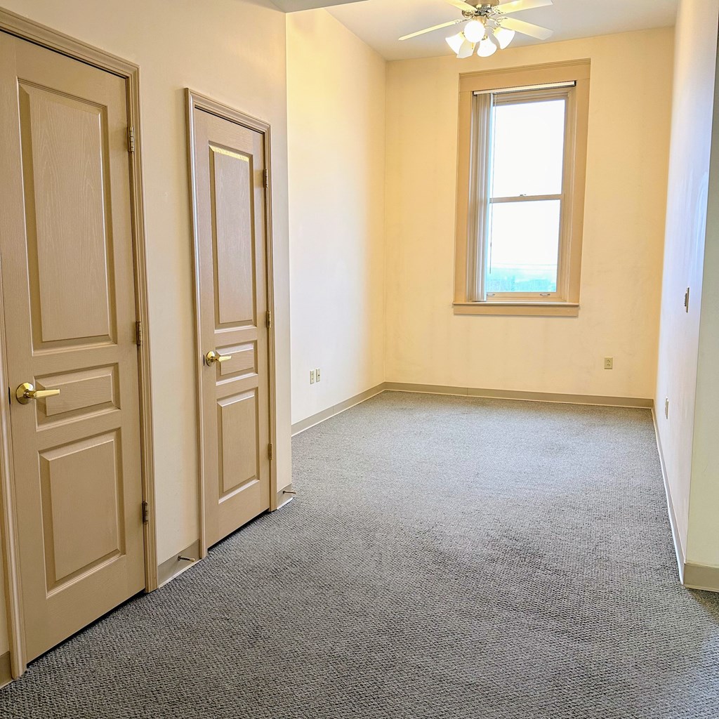 an empty room with a door and a window