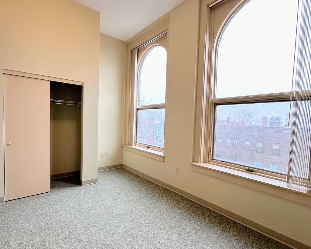 an empty room with large windows and a closet